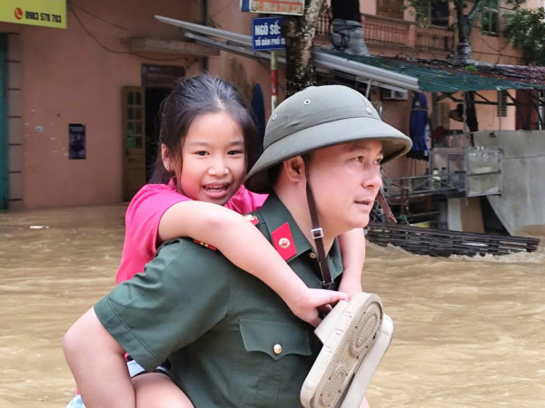 Cán bộ Công an xã cõng cháu bé qua vùng nước sâu nguy hiểm đến nơi an toàn