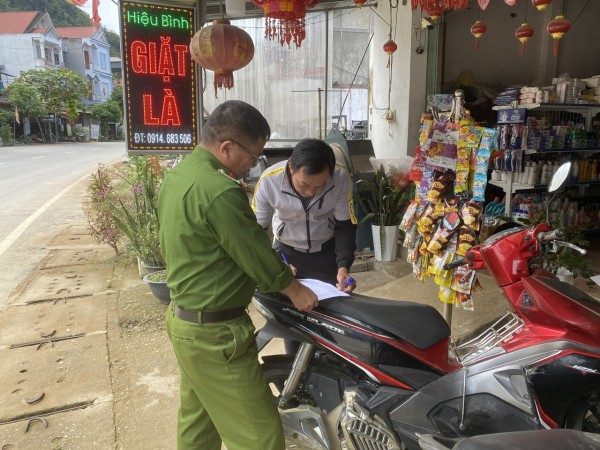 Ảnh 2  Cán bộ Công an đang hướng dẫn người dân kê khai phiếu thông tin giấy phép lái xe bìa bằng vật liệu giấy bìa