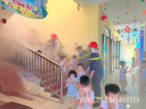 2 Cán bộ phòng Cảnh sát PCCC và CNCH hướng dẫn học sinh thoát nạn trong môi trường khói khí độc