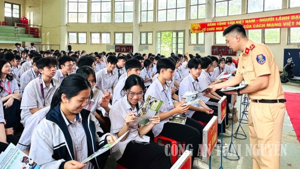 Cán bộ Phòng CSGT phát tờ rơi tuyên truyền cho các em học sinh nhà trường.