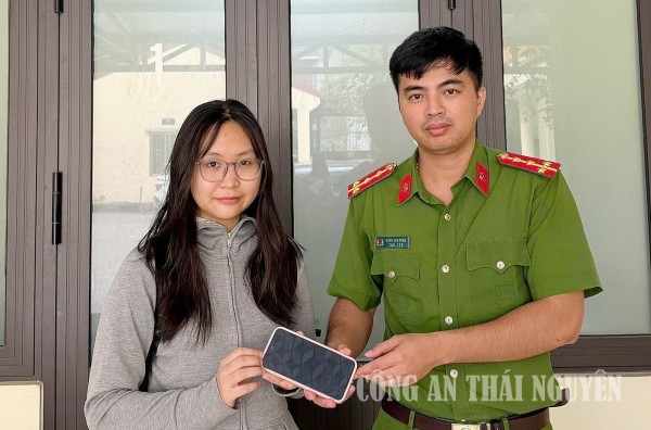Đồng chí Đặng Văn Tùng, cán bộ Công an phường trao trả tài sản nhặt được đến em Nguyễn Thuỳ Trang
