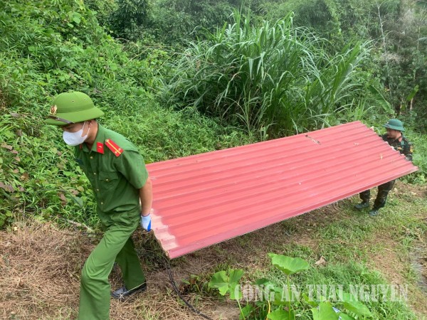 Công an xã hỗ trợ gia đình bà Dung vận chuyển vật liệu, lợp lại mái tôn, khắc phục hậu quả sau mưa lớn