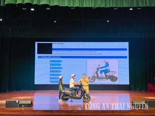 Lực lượng CSGT hướng dẫn các em học sinh tư thế ngồi trên xe an toàn.