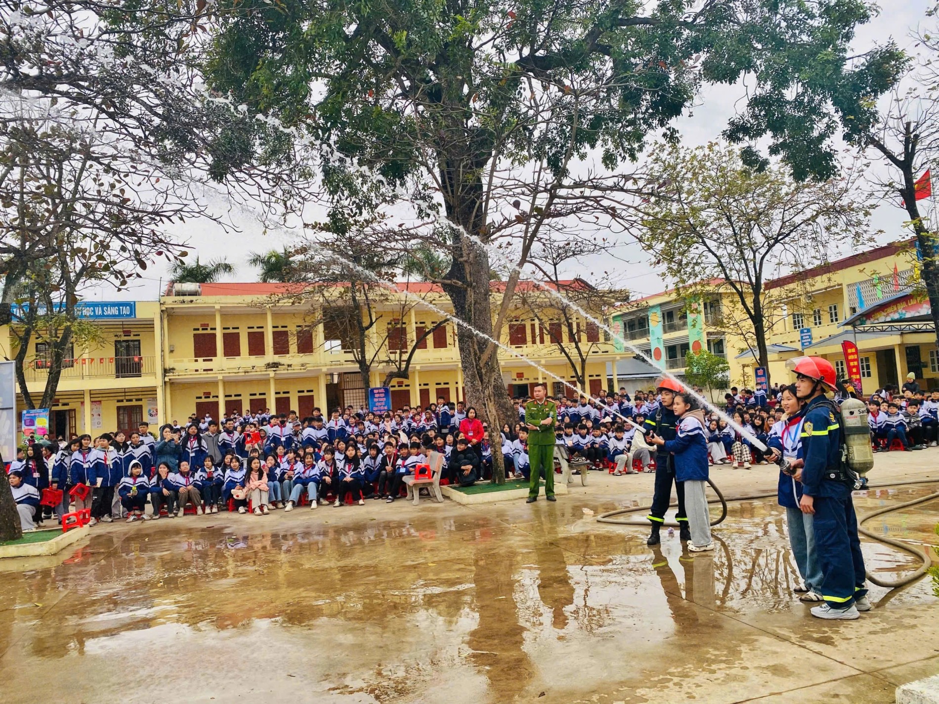 3 Lực lượng Cảnh sát PCCC và CNCH hướng dẫn học sinh sử dụng lăng vòi để dập tắt đám cháy giả định