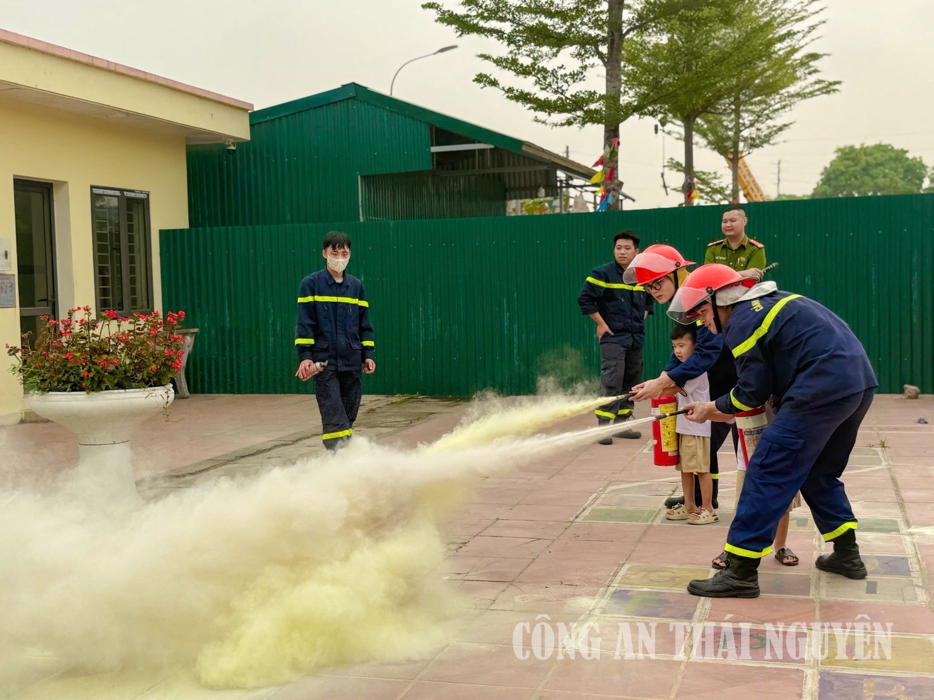 1 cán bộ Phòng Cảnh sát PCCC và CNCH hướng dẫn học sinh sử dụng bình chữa cháy