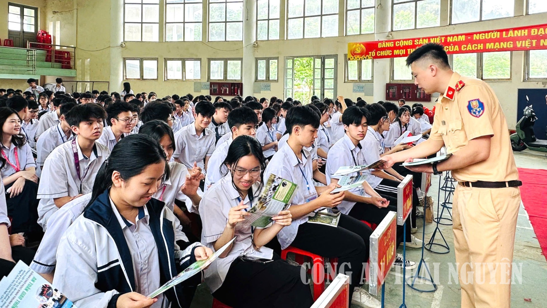 Cán bộ Phòng CSGT phát tờ rơi tuyên truyền cho các em học sinh nhà trường.