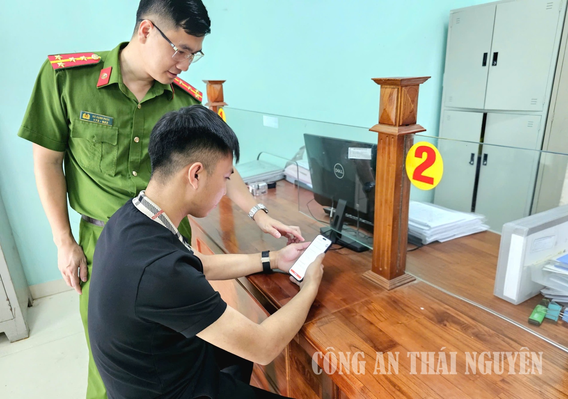 Cán bộ Công an xã hướng dẫn người dân các bước thực hiện việc lấy ý kiến đánh giá qua ứng dụng VNeID