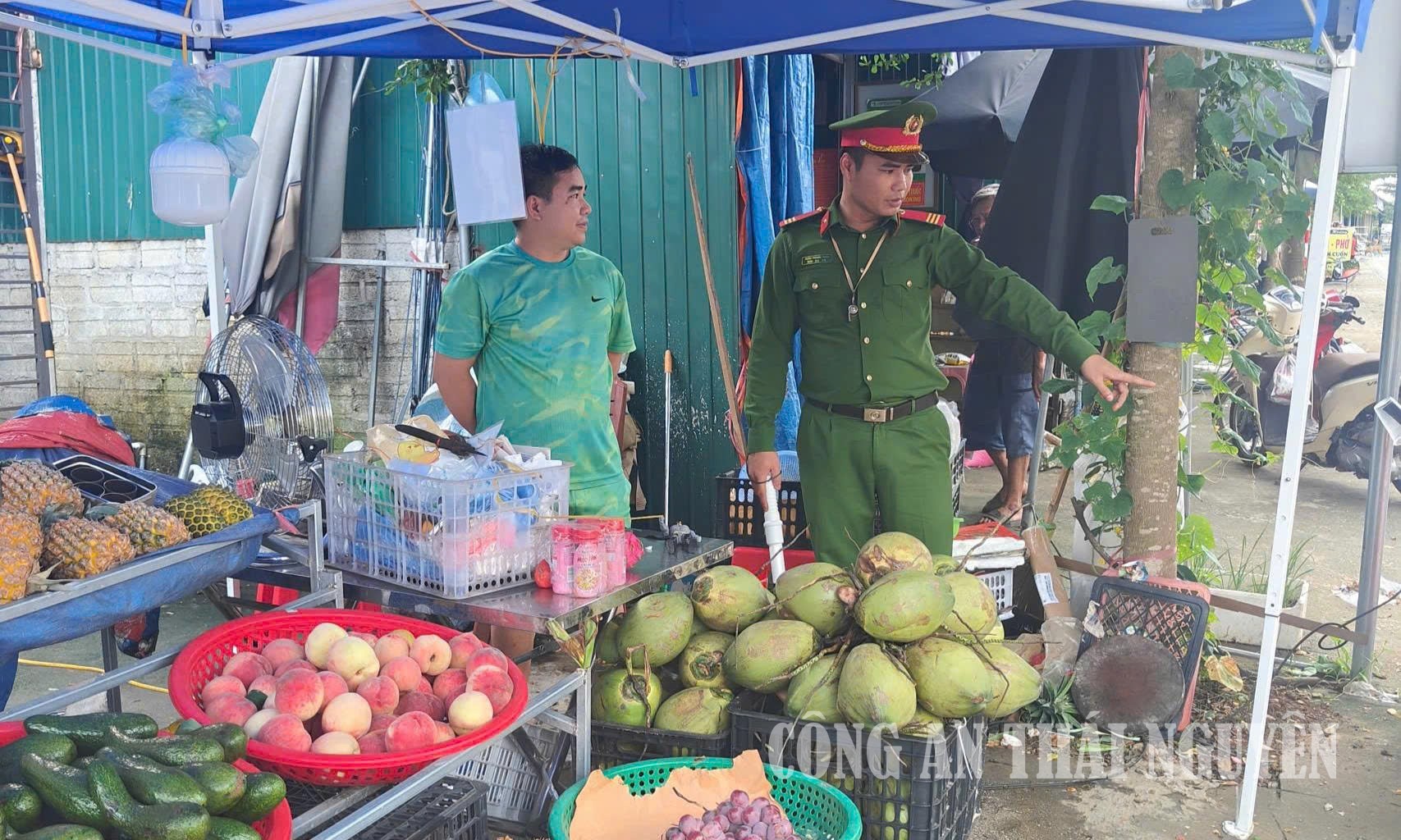 Cán bộ Công an xã nhắc nhở người dân không để vật dụng lấn chiếm vỉa hè