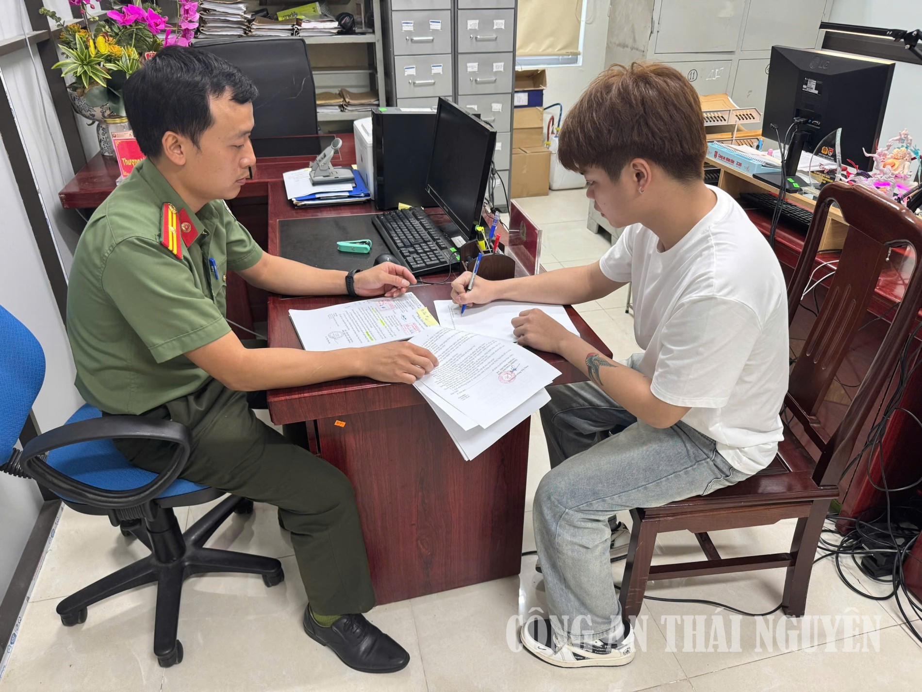 Cán bộ Phòng Quản ký xuất nhập cảnh hướng dẫn công dân viết cam kết không vi phạm pháp luật về xuất nhập cảnh.