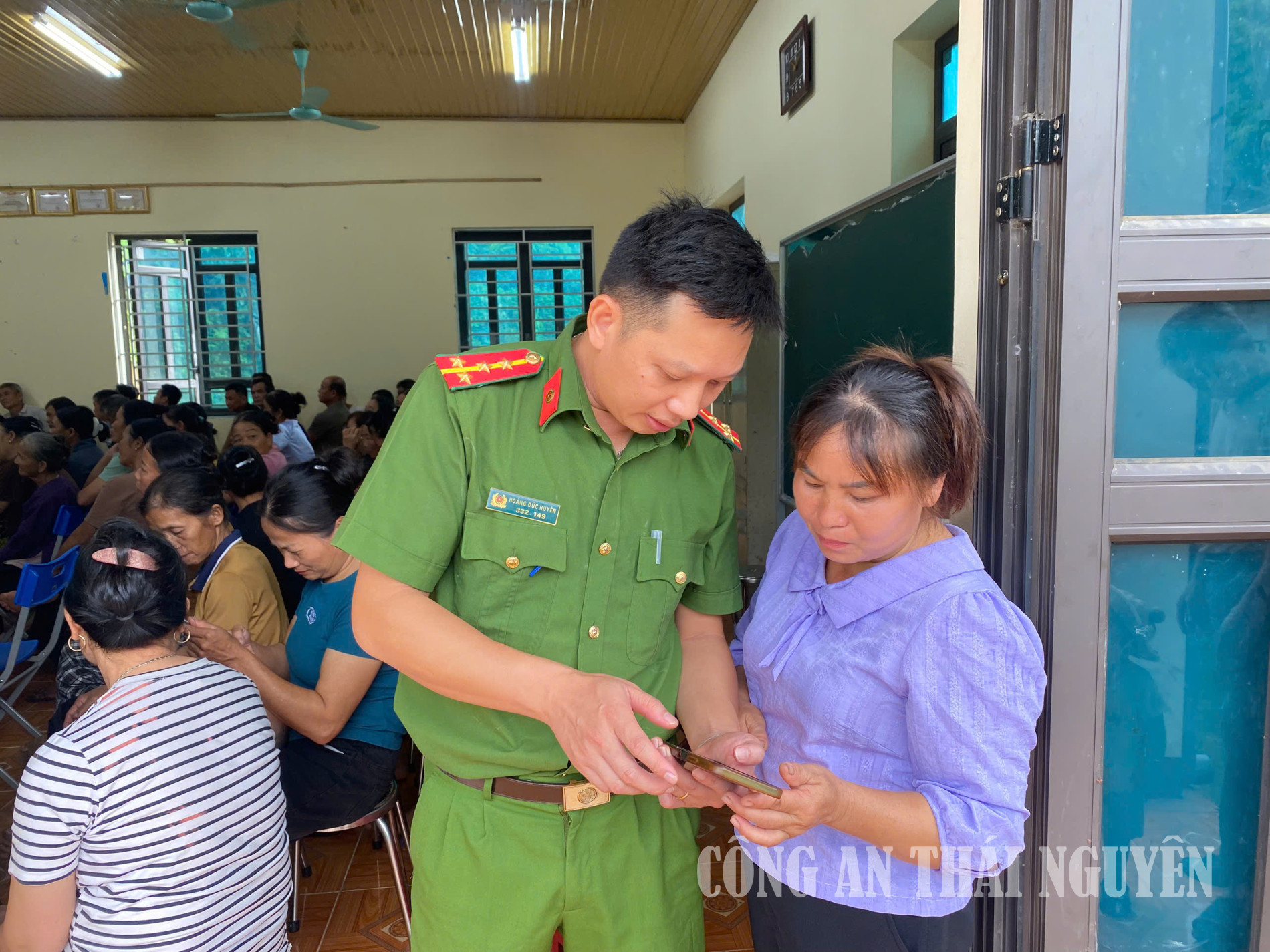 Công an xã hướng dẫn người dân cài đặt ứng dụng VNeTraffic trên điện thoại thông minh.