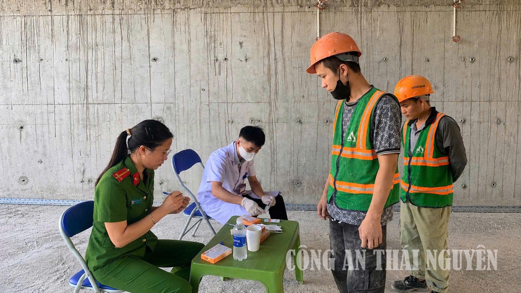 Cán bộ Công an phường kiểm tra nhanh chất ma túy trong cơ thể đối với công nhân công trường xây dựng