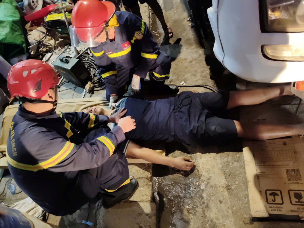 Lực lượng cứu nạn trấn an nạn nhân sau khi đưa ra khỏi gầm xe