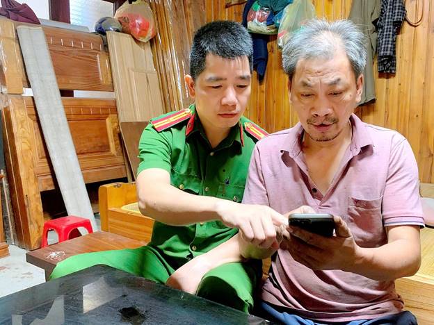 Cán bộ Công an phường Đức Xuân hướng dẫn người dân sử dụng các tiện ích số tại gia đình