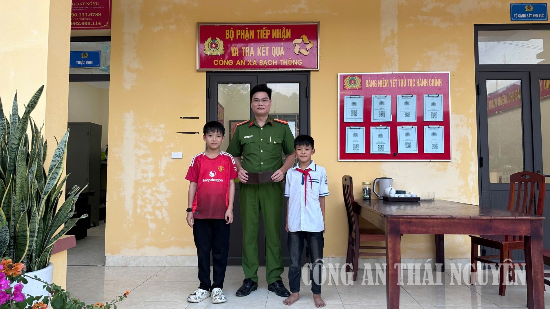 Cán bộ Công an xã tiếp nhận tài sản từ hai cháu học sinh